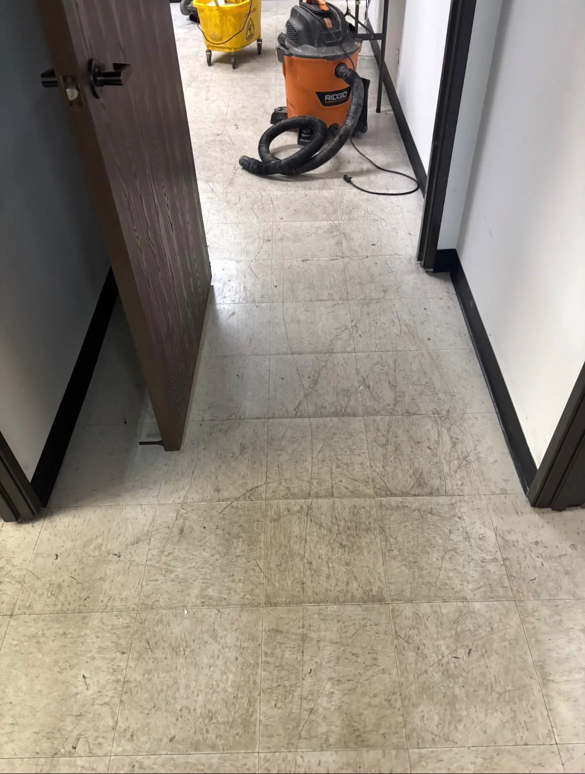 Hallway tile floor before cleaning, dull and dirty