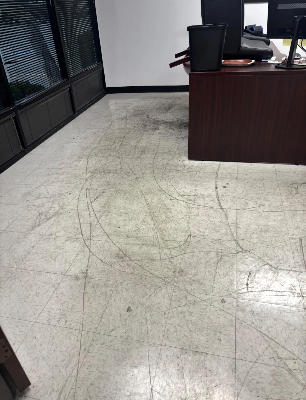 Office tile floor before cleaning, heavily scuffed